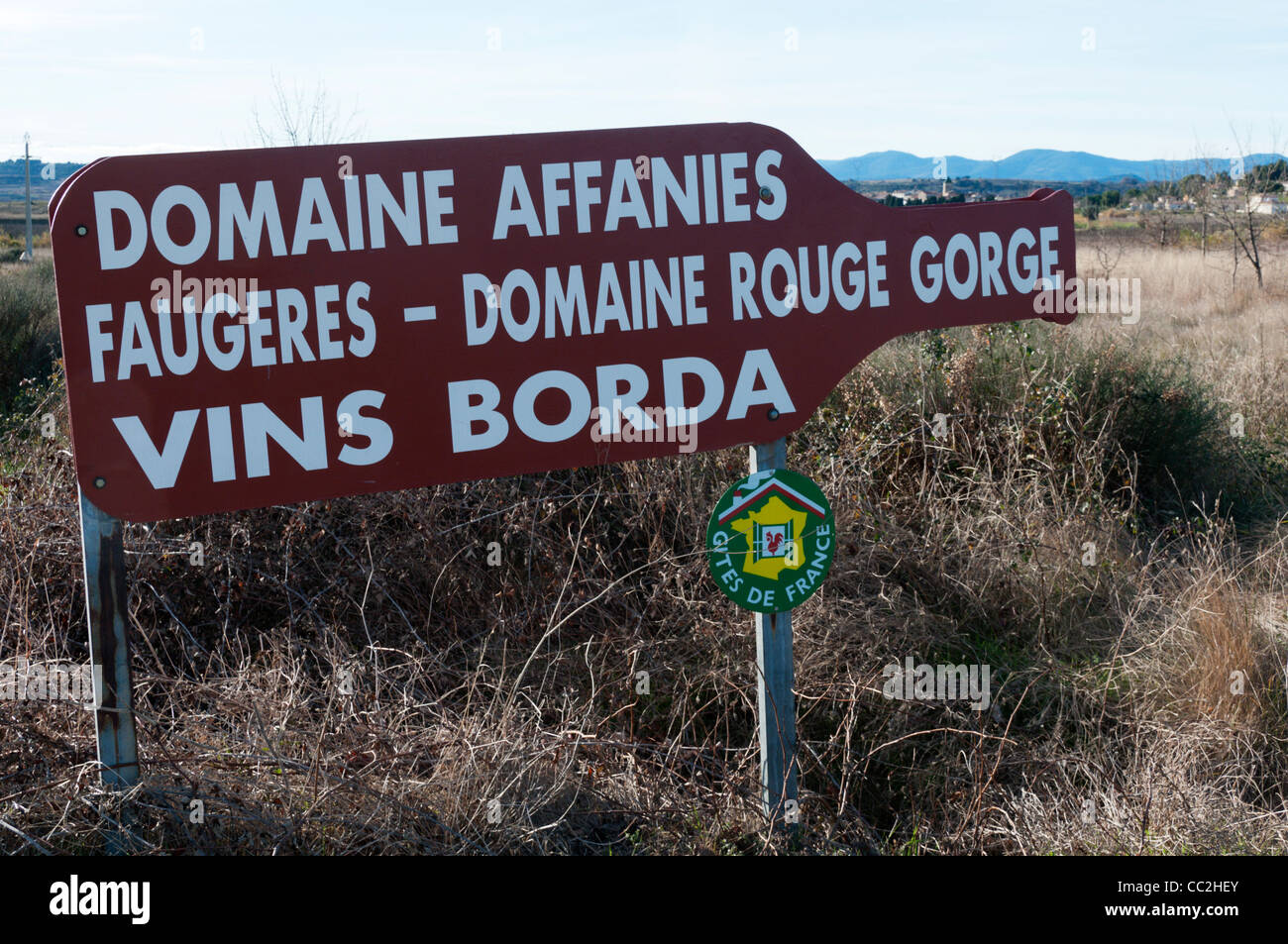 Wegweiser zu Weinbergen im Languedoc, Frankreich, in der Form einer Weinflasche. Links zeigt Zeichen finden Sie unter CC2HF1. Stockfoto