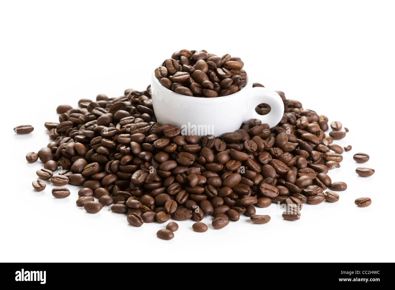 Kaffee Espressotasse gefüllt mit und unter den gerösteten Kaffeebohnen isoliert auf weißem Hintergrund Stockfoto