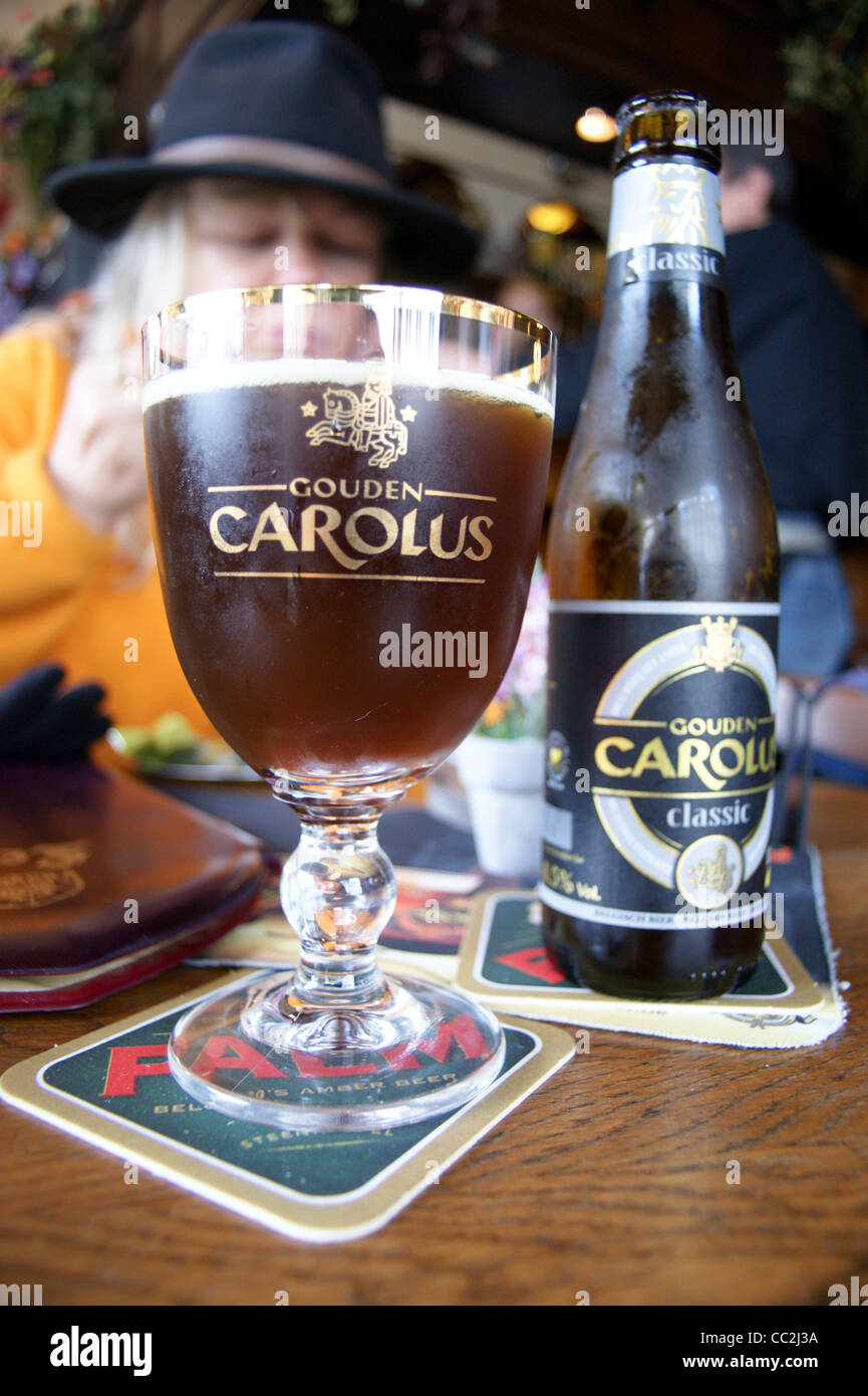 Ein bedrucktes Glas Gouden Carolus klassischen dunklen Belgischen Bier aus der Brauerei Het Anker, Antwerpia Bar, Cafe, Mechelen, Belgien mit seiner Flasche Stockfoto