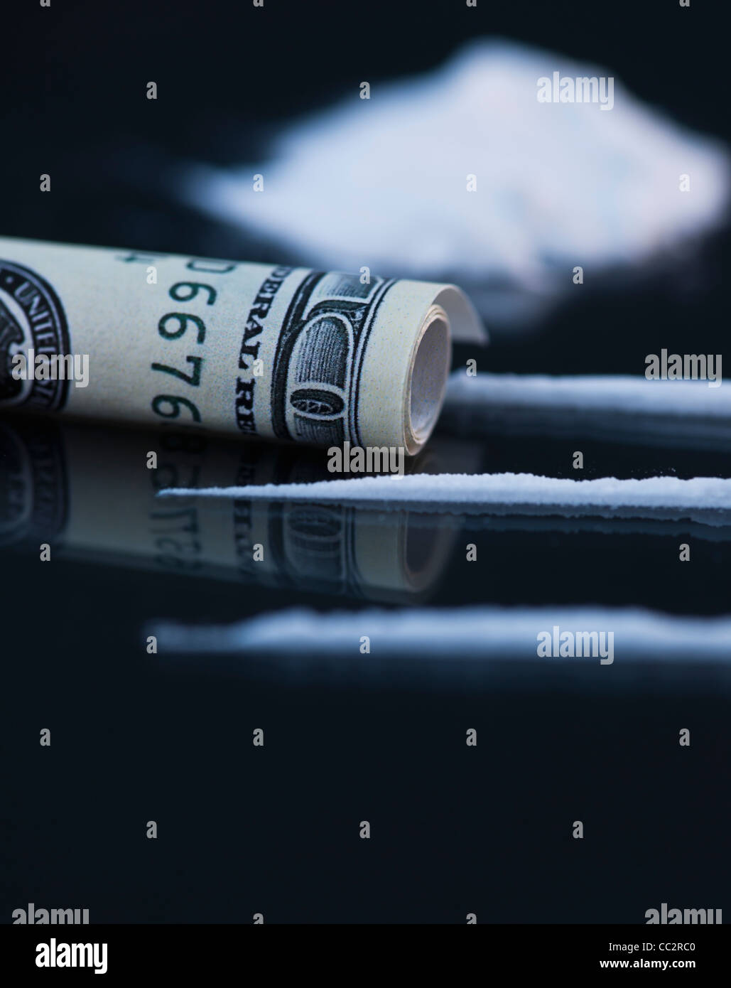 Nahaufnahme von Kokain und zusammengerollten Geldschein auf schwarzem Hintergrund Stockfoto