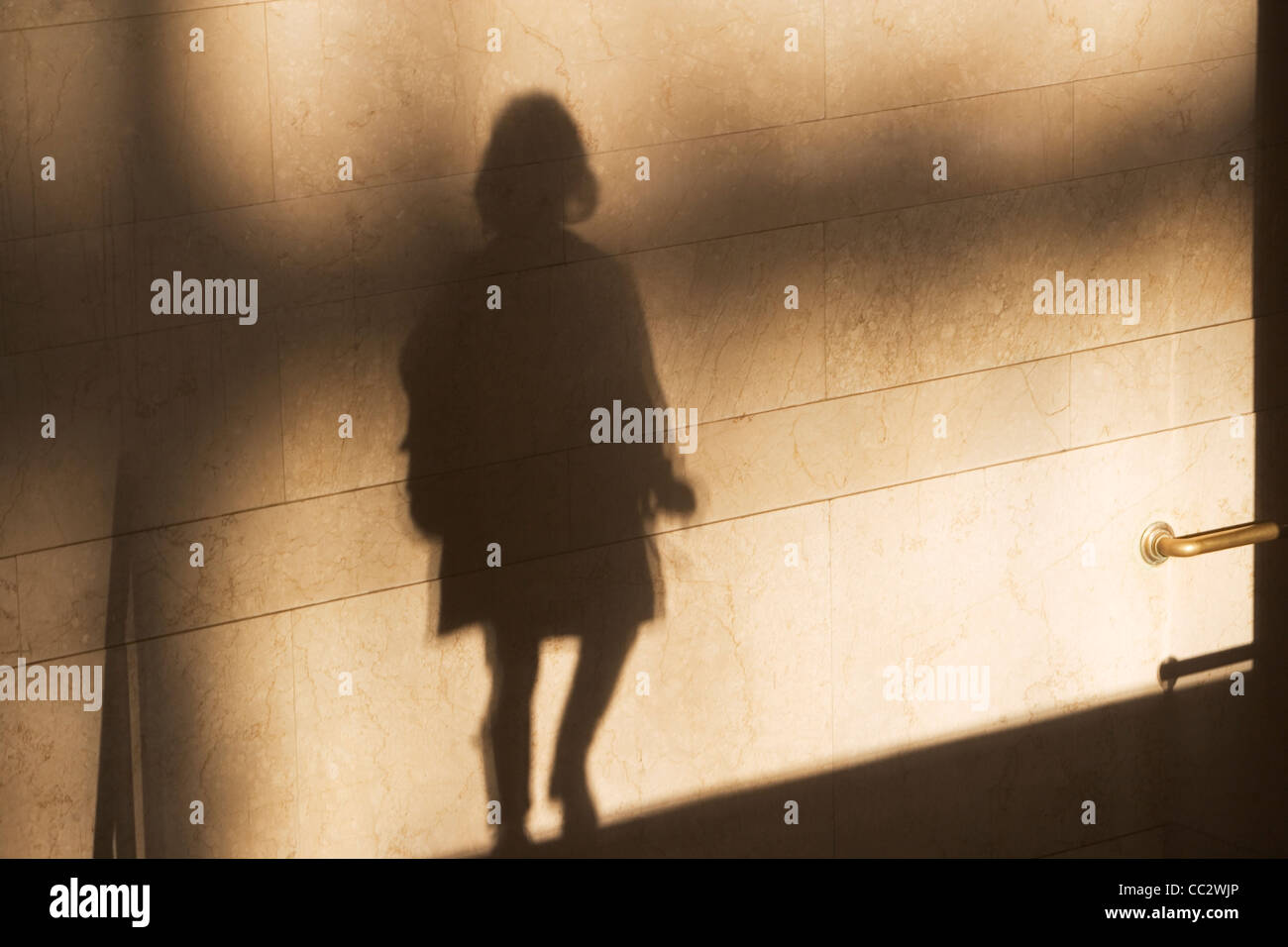 USA, New York City, Schatten des einzigen männlichen Fußgänger an sonnenbeschienenen Wand Stockfoto