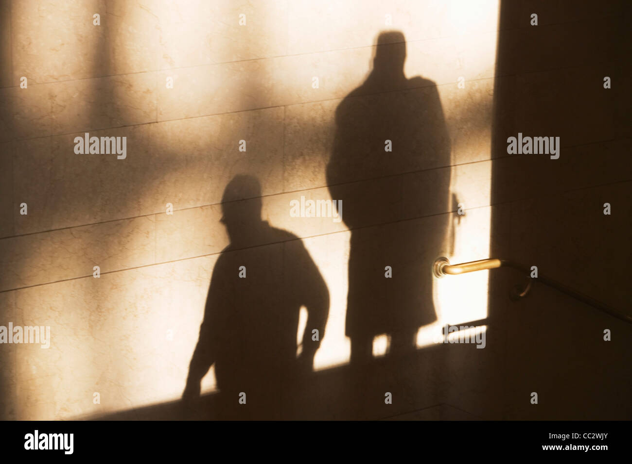 USA, New York City, Schatten von zwei männlichen Passanten an sonnenbeschienenen Wand Stockfoto