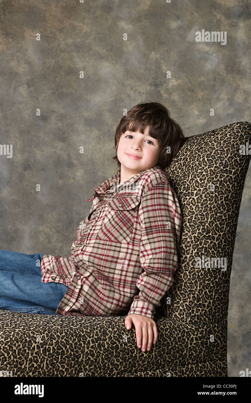 Porträt eines jungen (6-7) auf Stuhl sitzend mit Tier drucken, Studio gedreht Stockfoto