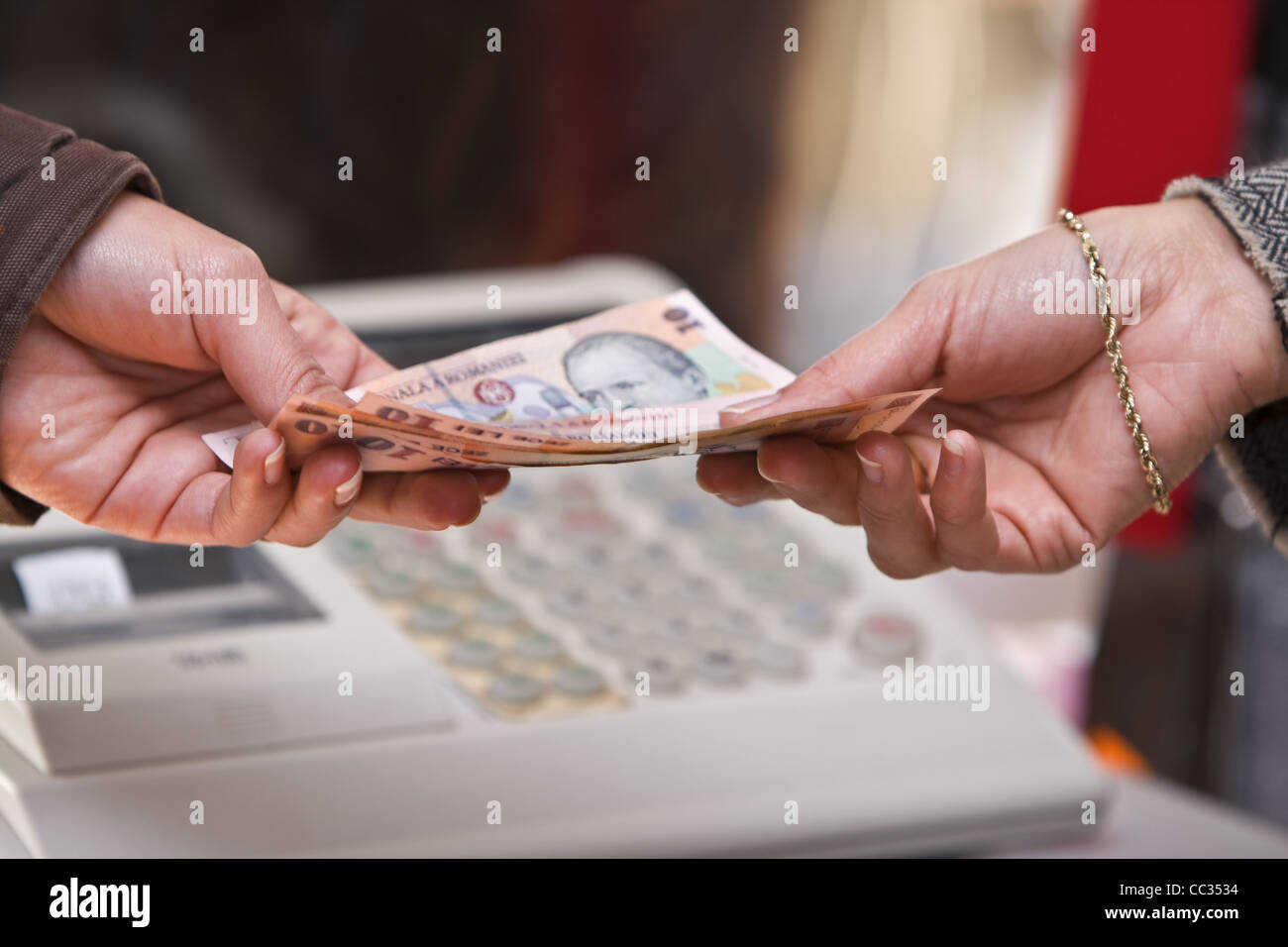 Detail der Hand einer Frau während sie im Shop (rumänische Geld) bezahlt. Stockfoto