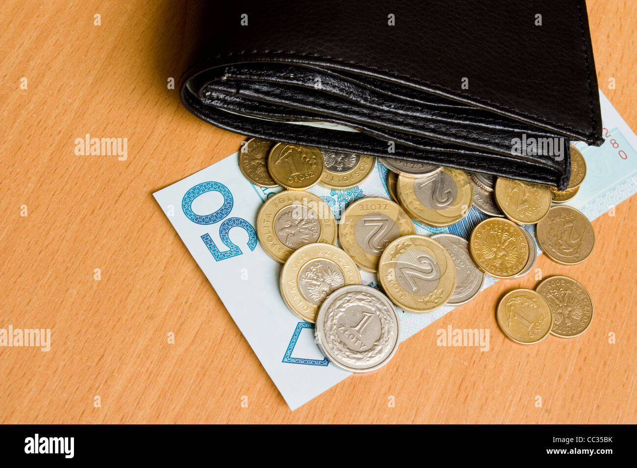 polnisches Geld - Zloty - Münzen und Banknoten und Brieftasche auf dem Tisch Stockfoto