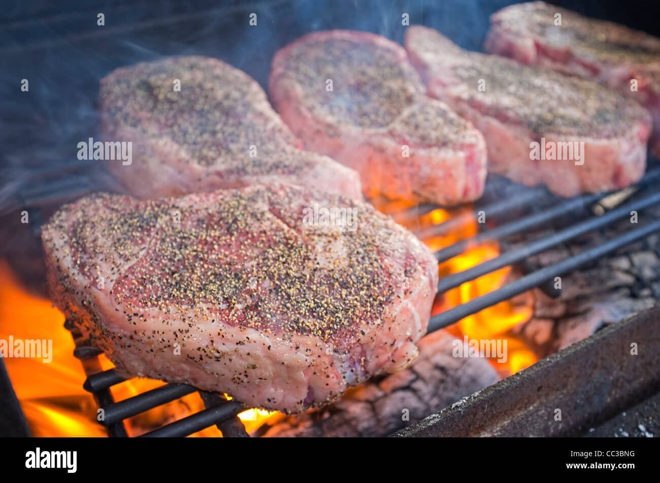 Beef Ribeye Steaks grillen über heißes Feuer Stockfoto