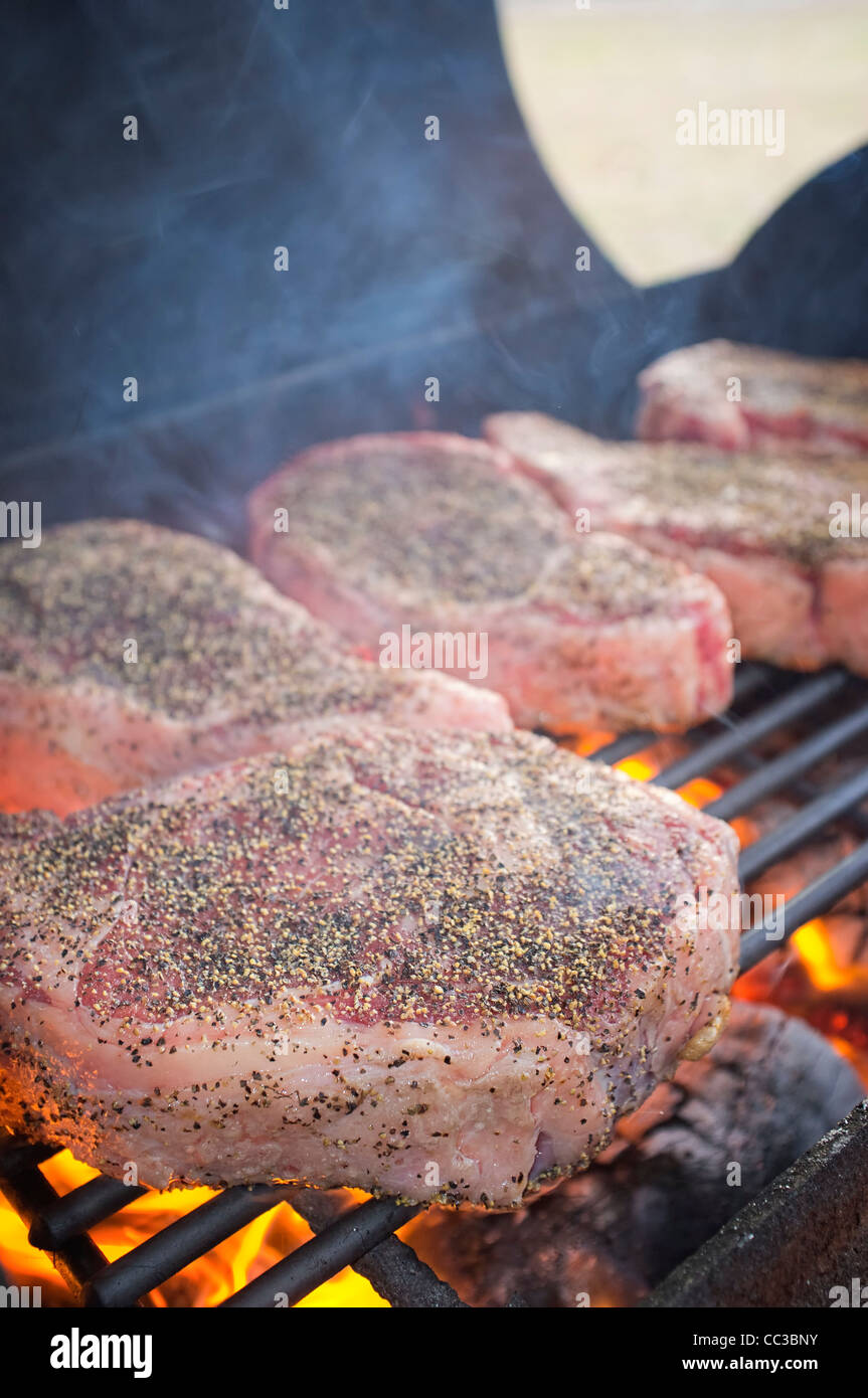 Nahaufnahme von Ribeye Steaks Grillen auf Grill Feuerstelle Stockfoto