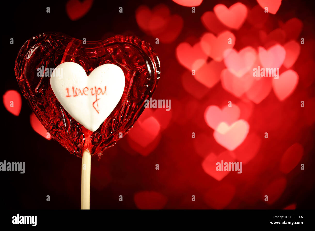 Rotes Herz Form Lutscher auf defokussierten Bokeh Hintergrund Stockfoto