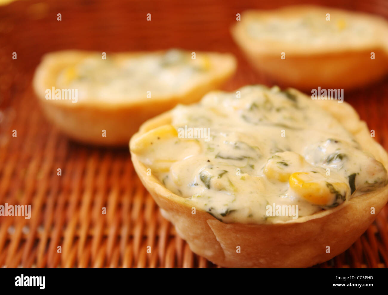 Detail-Aufnahme von Mais und Spinat Herb Set auf einem Stock Korb hautnah. Zwei weitere herzhaften Torten sind in den Hintergrund gesetzt. Stockfoto
