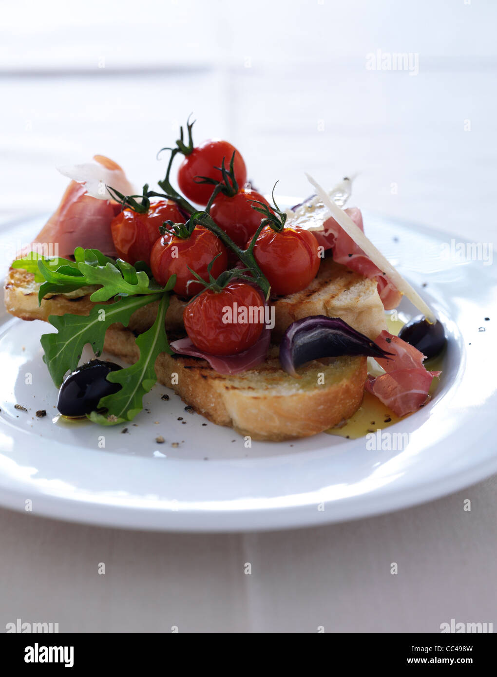 Bruschetta mit gerösteten Gemüse Parma Schinken und Parmesan-Späne Stockfoto