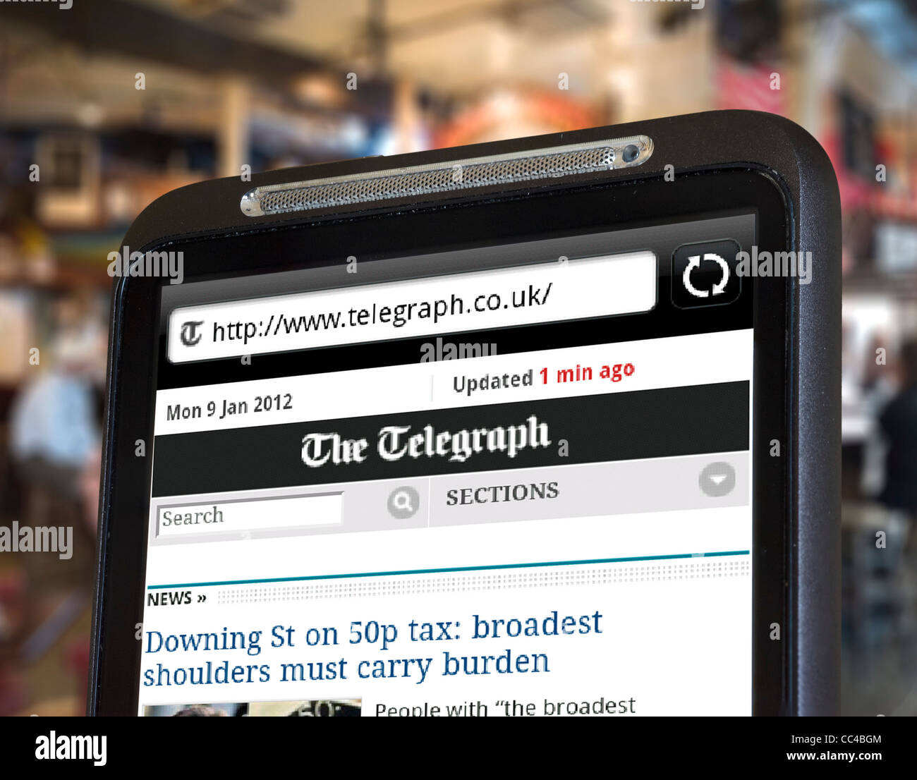 Readomg der Daily Telegraph Online-Zeitung auf einem HTC-Smartphone über einen öffentlichen WLAN-hotspot Stockfoto