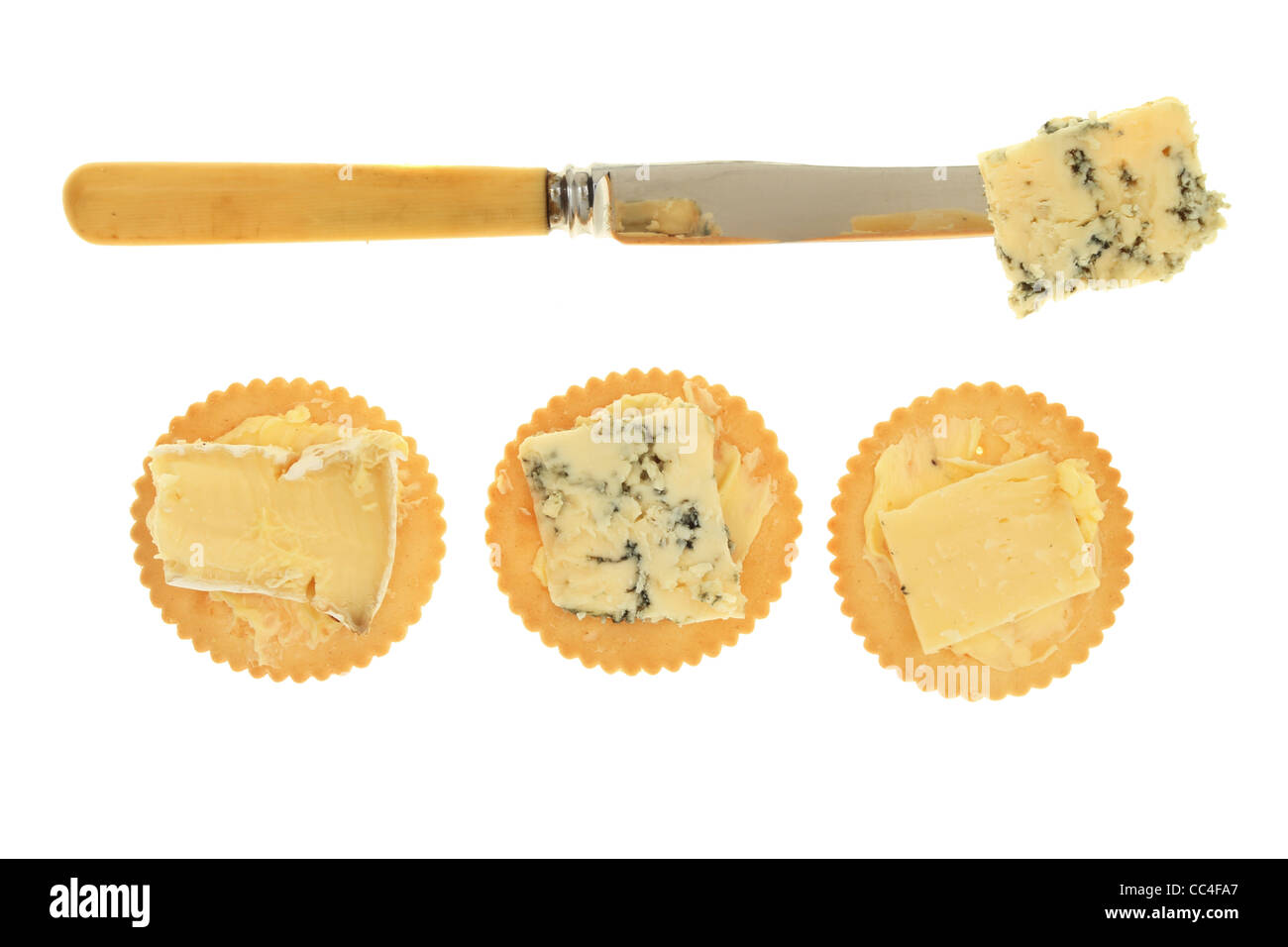 Käse auf Kekse mit einem Messer isoliert gegen weiß Stockfoto