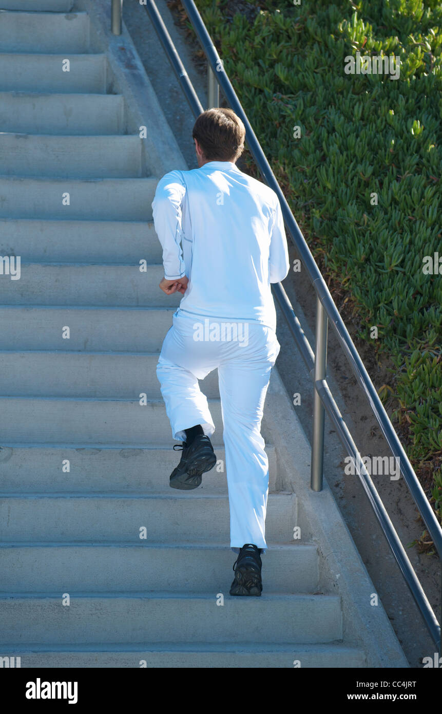 Ein Mann gekleidet in weiß, die Treppe hinauf laufen. Stockfoto