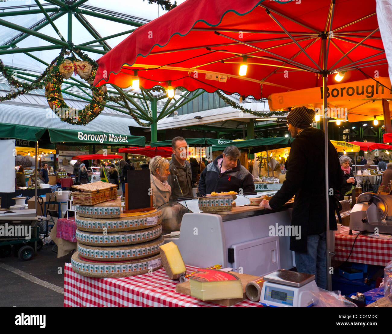 Käse-Stall mit Proben im Borough Market mit Weihnachtsschmuck Southwark London Stockfoto