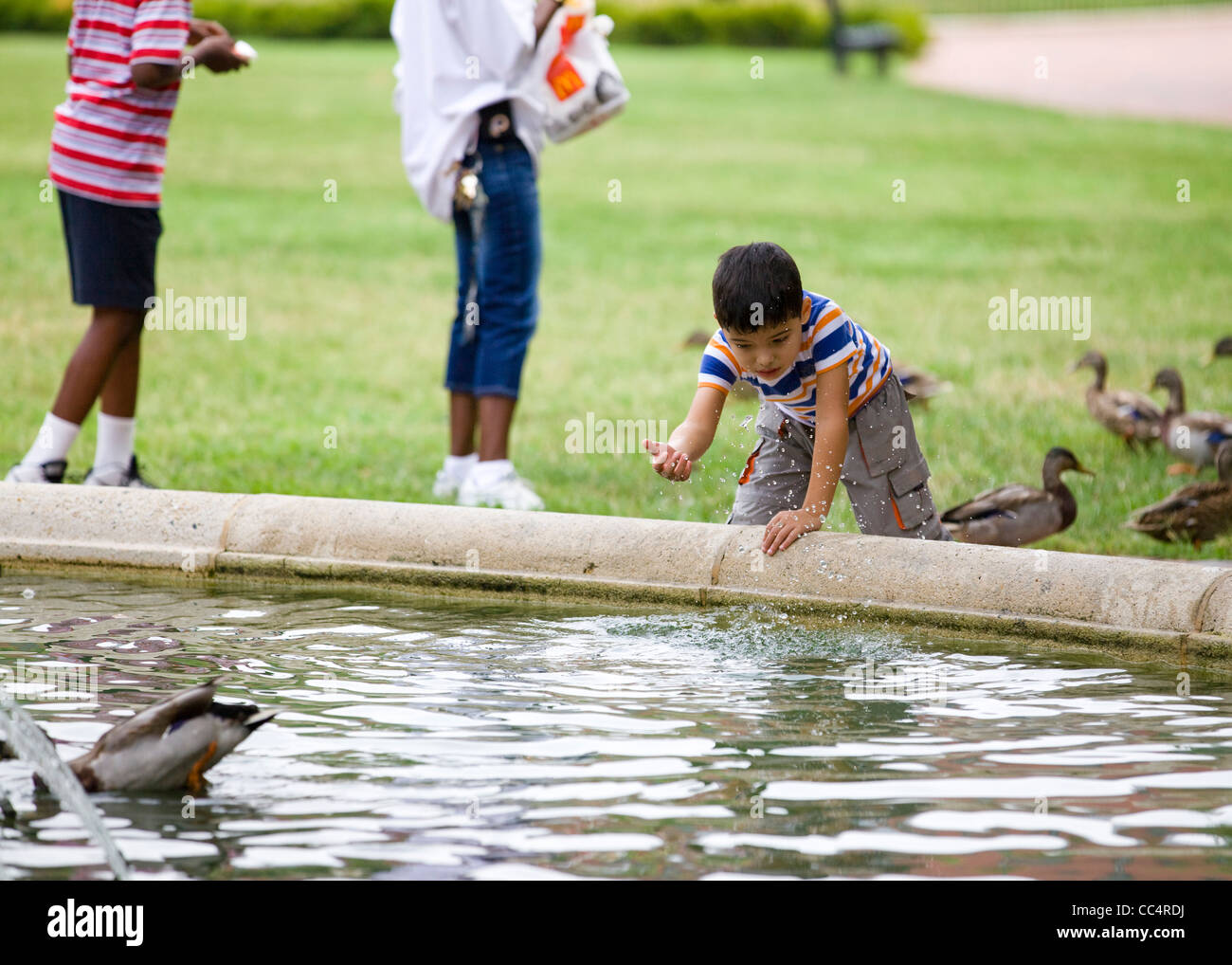 Ein Junge spielt im Park Brunnen Stockfoto