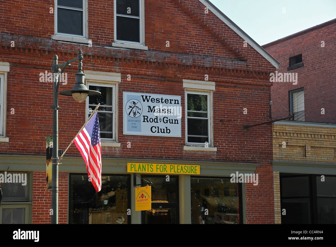 Anzeichen für den Western Massachusetts Rod and Gun Club und für ein Blumengeschäft auf einem Backsteingebäude Stockfoto