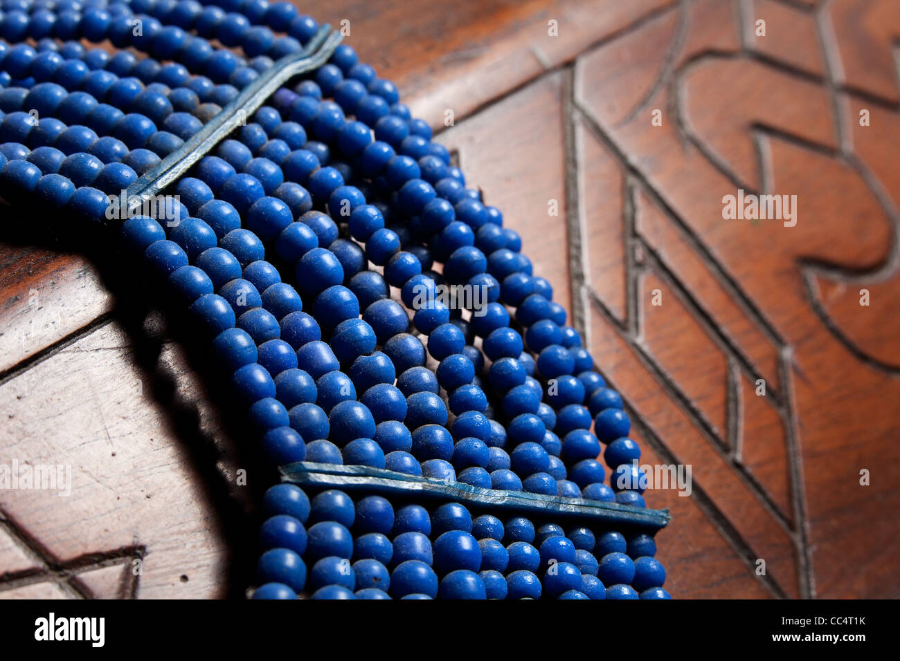 Afrikanische Stammes-Blau Halskette auf Holzmöbeln Hintergrund platziert. traditionellen einheimischen Kunsthandwerk. Stockfoto