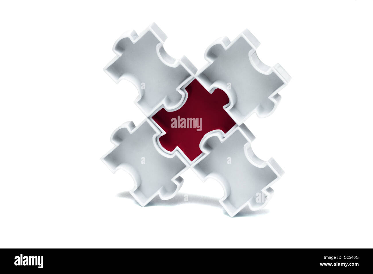 Roten Jigsaw Puzzle verriegelt im Zentrum mit weißen Steinen Stockfoto