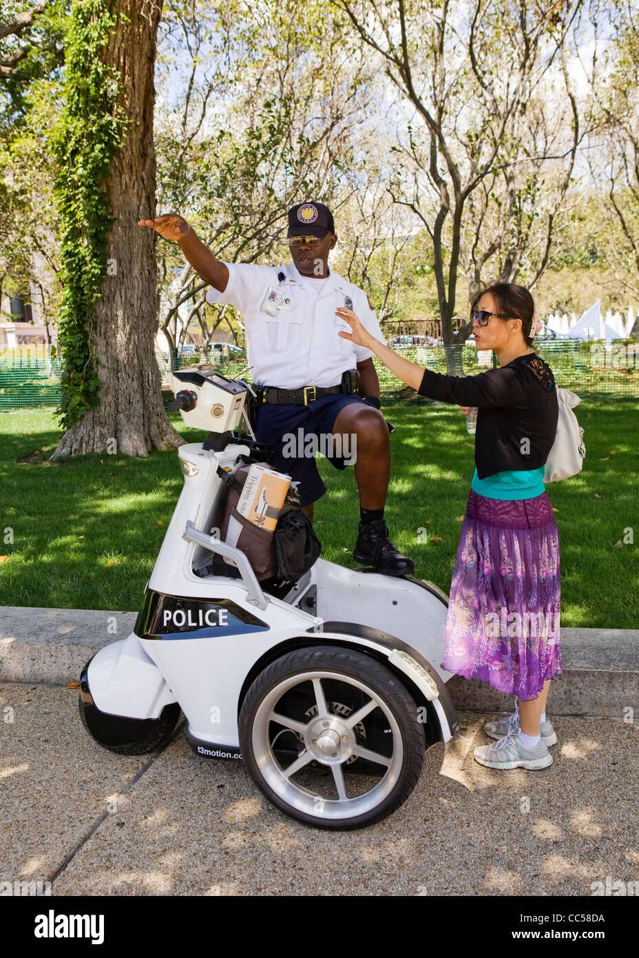 Ein Polizist auf einem ESV (stehend Elektrofahrzeug) hilft ein weiblicher Zivilist - Washington, DC USA Stockfoto