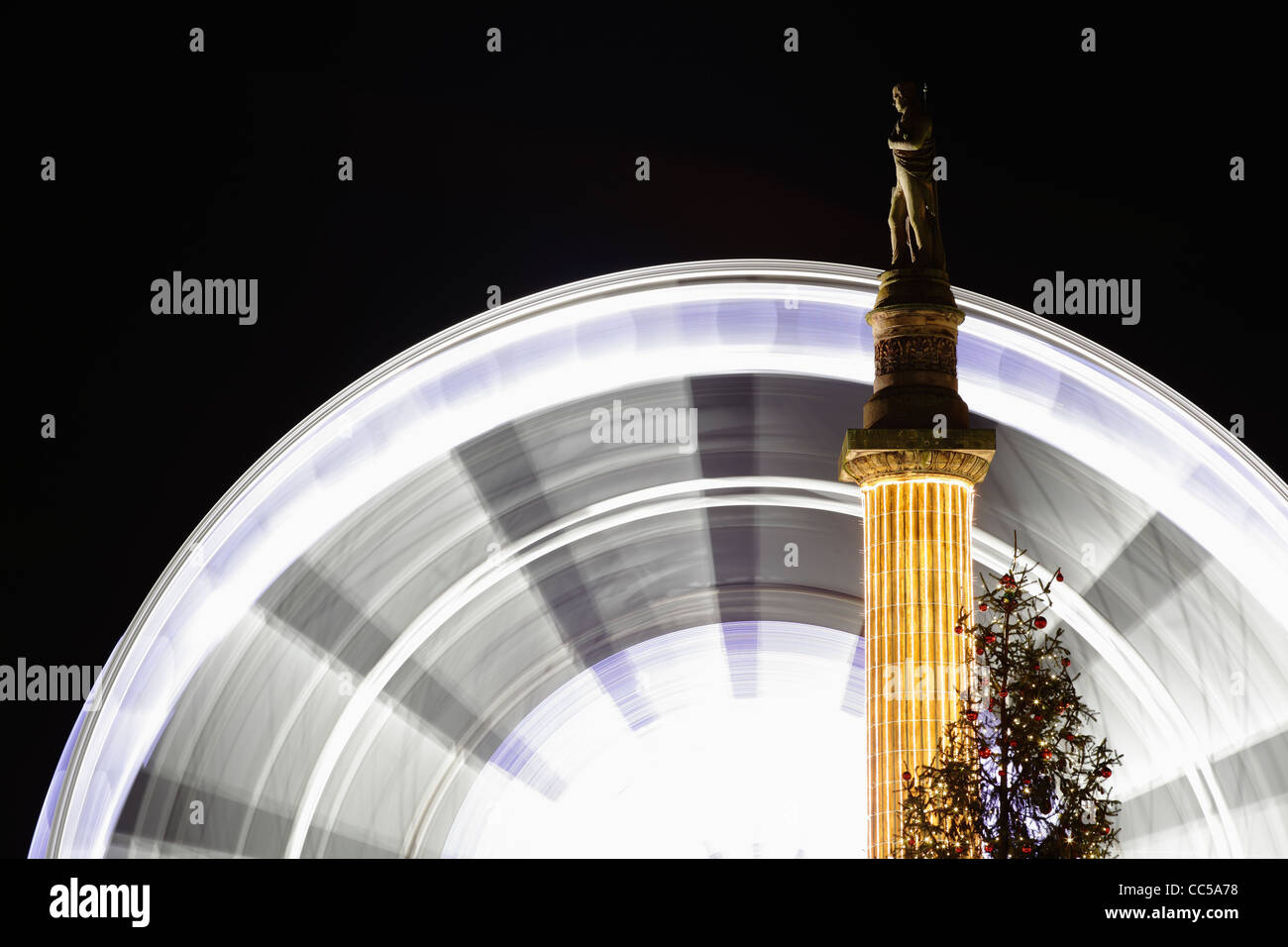 Großes Rad dreht sich neben der Statue von Sir Walter Scott bei Nacht, George Square, Glasgow, Schottland, Großbritannien Stockfoto