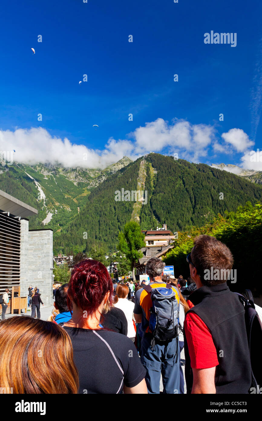 Touristen, die Schlange für die Seilbahn auf den Gipfel des Mont-Blanc in Chamonix französischen Alpen mit Gleitschirme in den Himmel Stockfoto