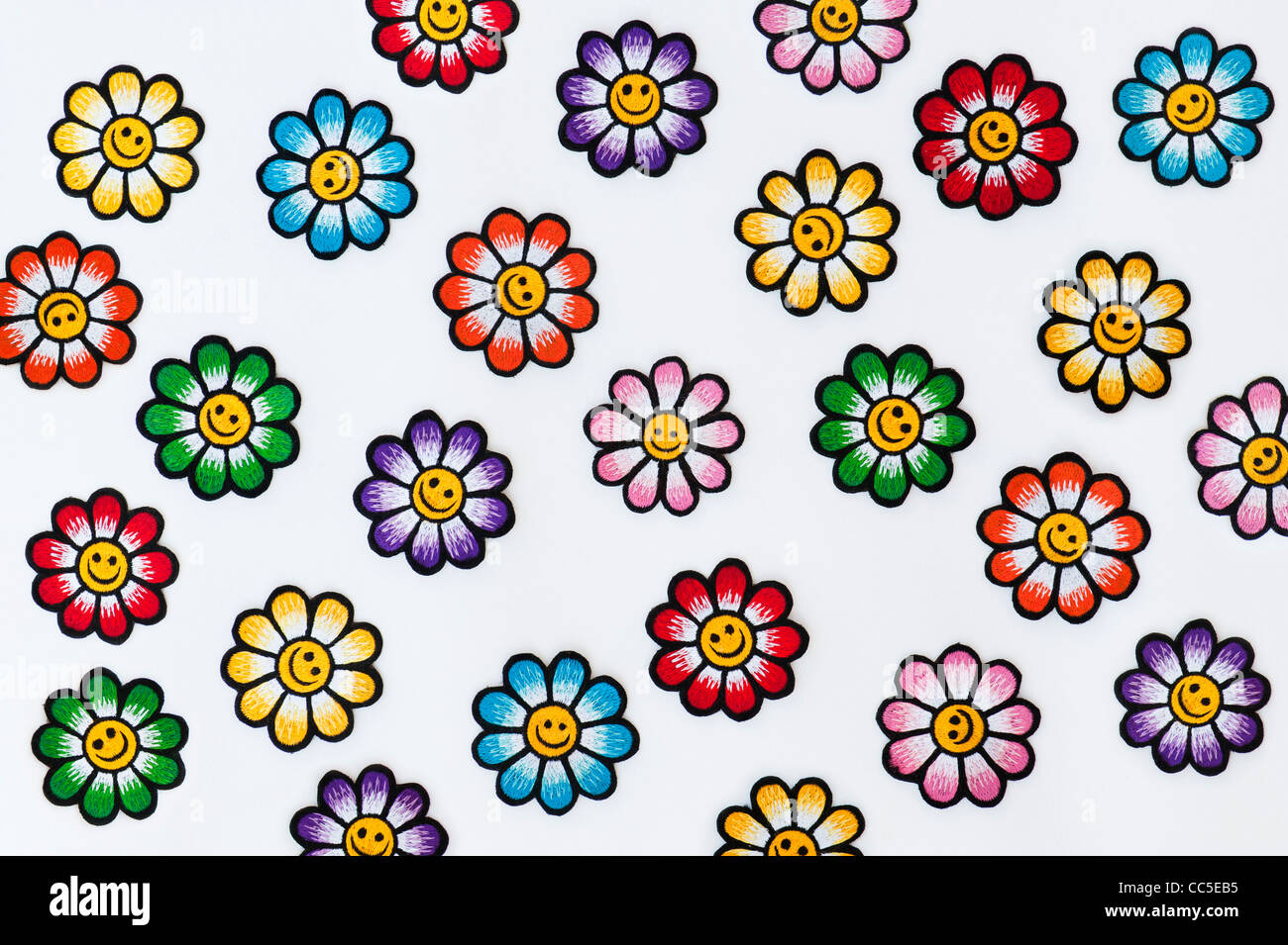Stickerei-Eisen auf Flecken von bunten Smiley Gesicht Blumen auf weißem Hintergrund Stockfoto