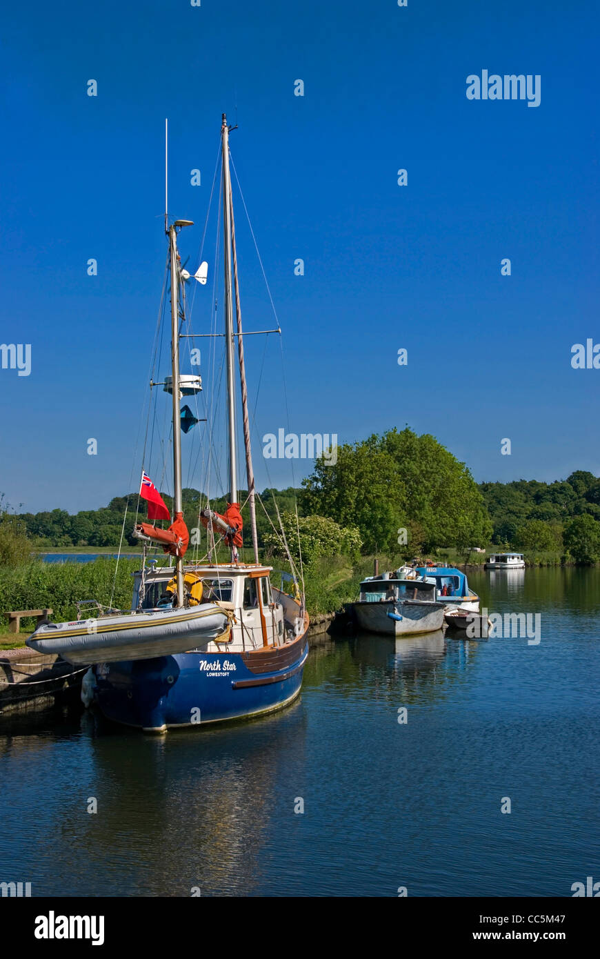 Boote und Segelschiff vor Anker, entlang des Flusses Yare, Nr Thorpe St Andrew, auf den Norfolk Broads, Norwich, Norfolk Stockfoto