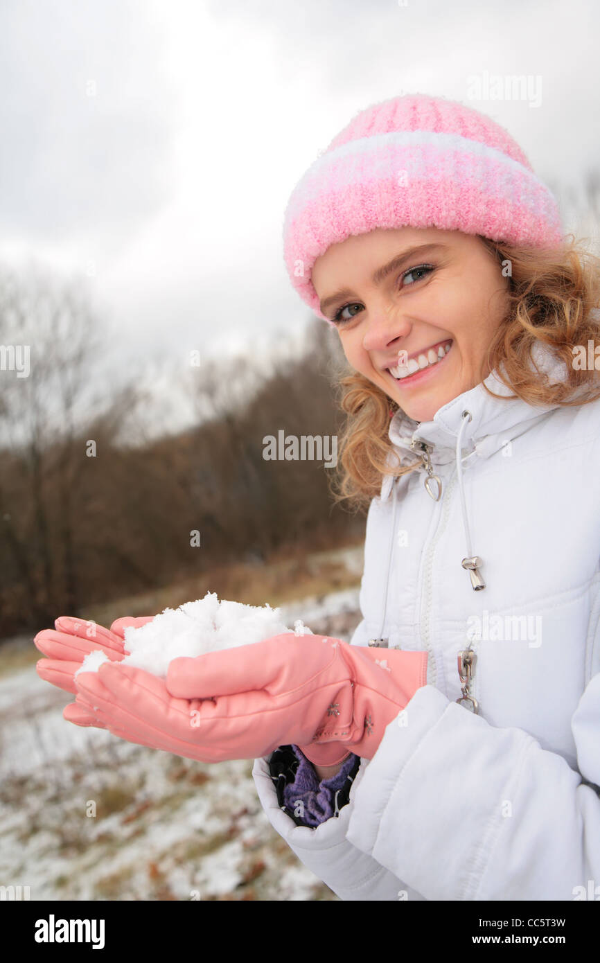 junge Schönheit Mädchen im Freien im Winter hält Schnee in Händen Stockfoto