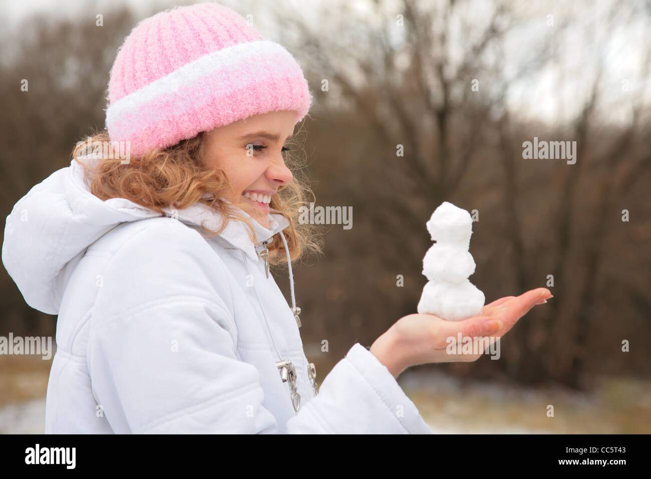 junge Schönheit Mädchen im Freien im Winter hält kleine Schneemann in Händen. Stockfoto