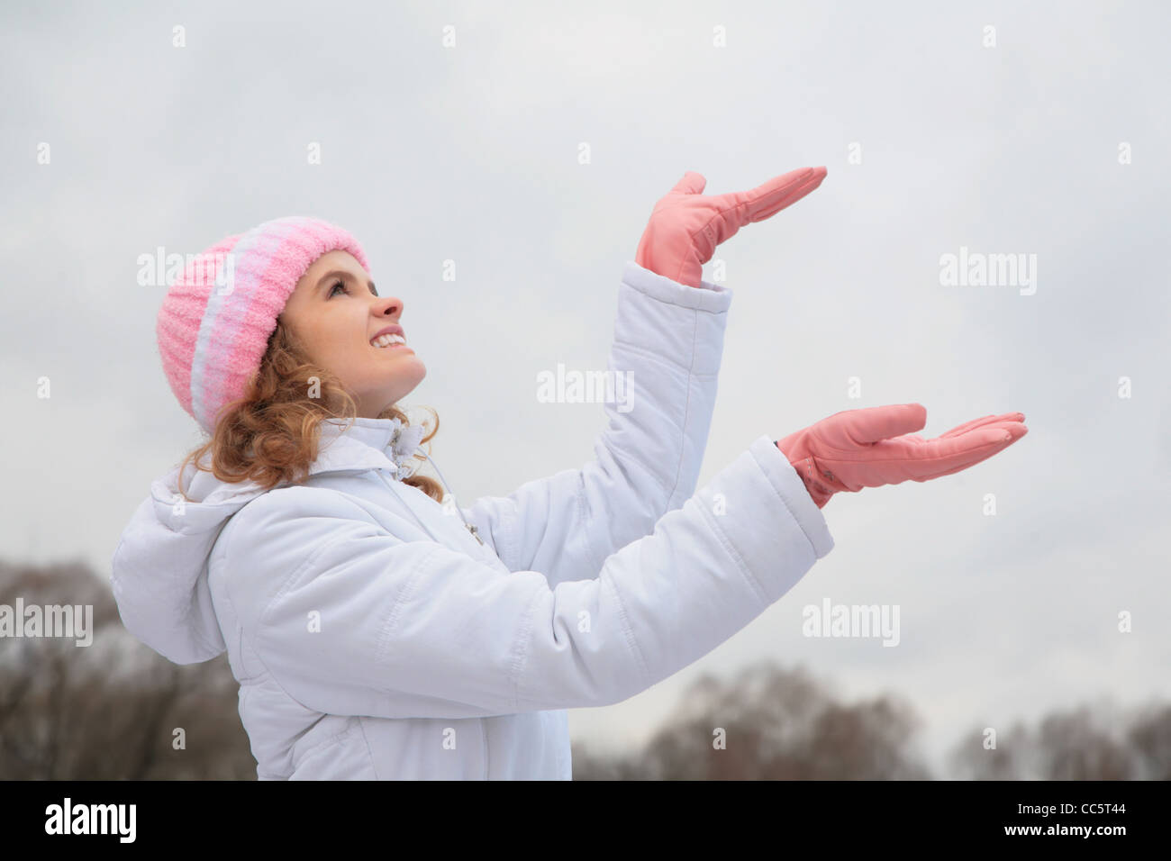 junge Schönheit Mädchen im Freien im Winter fängt Schneeflocken Stockfoto