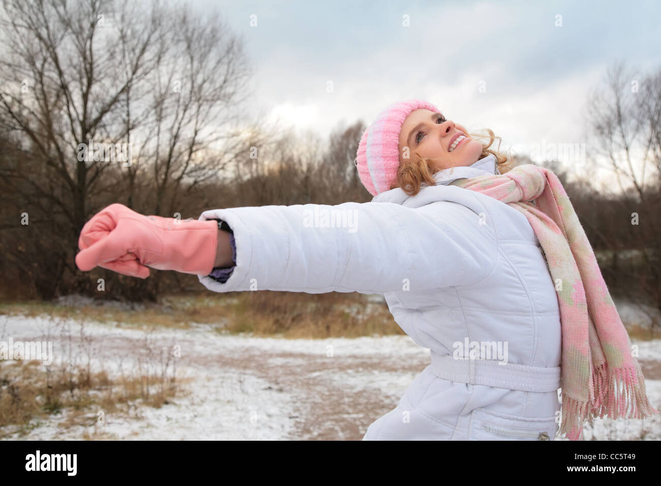 junge Schönheit Mädchen aus Holz im Winter mit gestreckten Händen Stockfoto