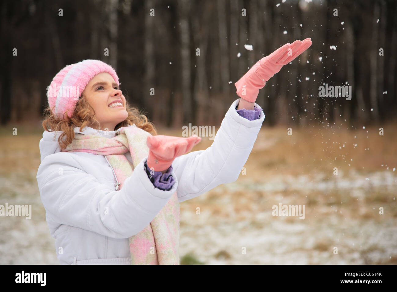 junge Schönheit Mädchen aus Holz im Winter fängt Schneeflocken Stockfoto