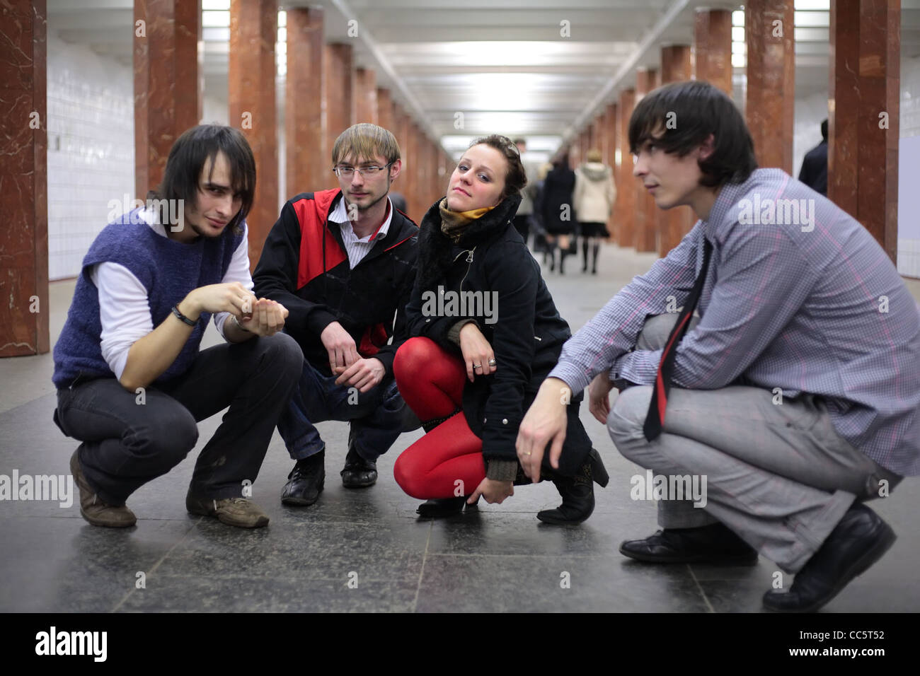 Gruppe junger Freunde auf u-Bahnstation, Schwerpunkt Mann in Gläsern Stockfoto