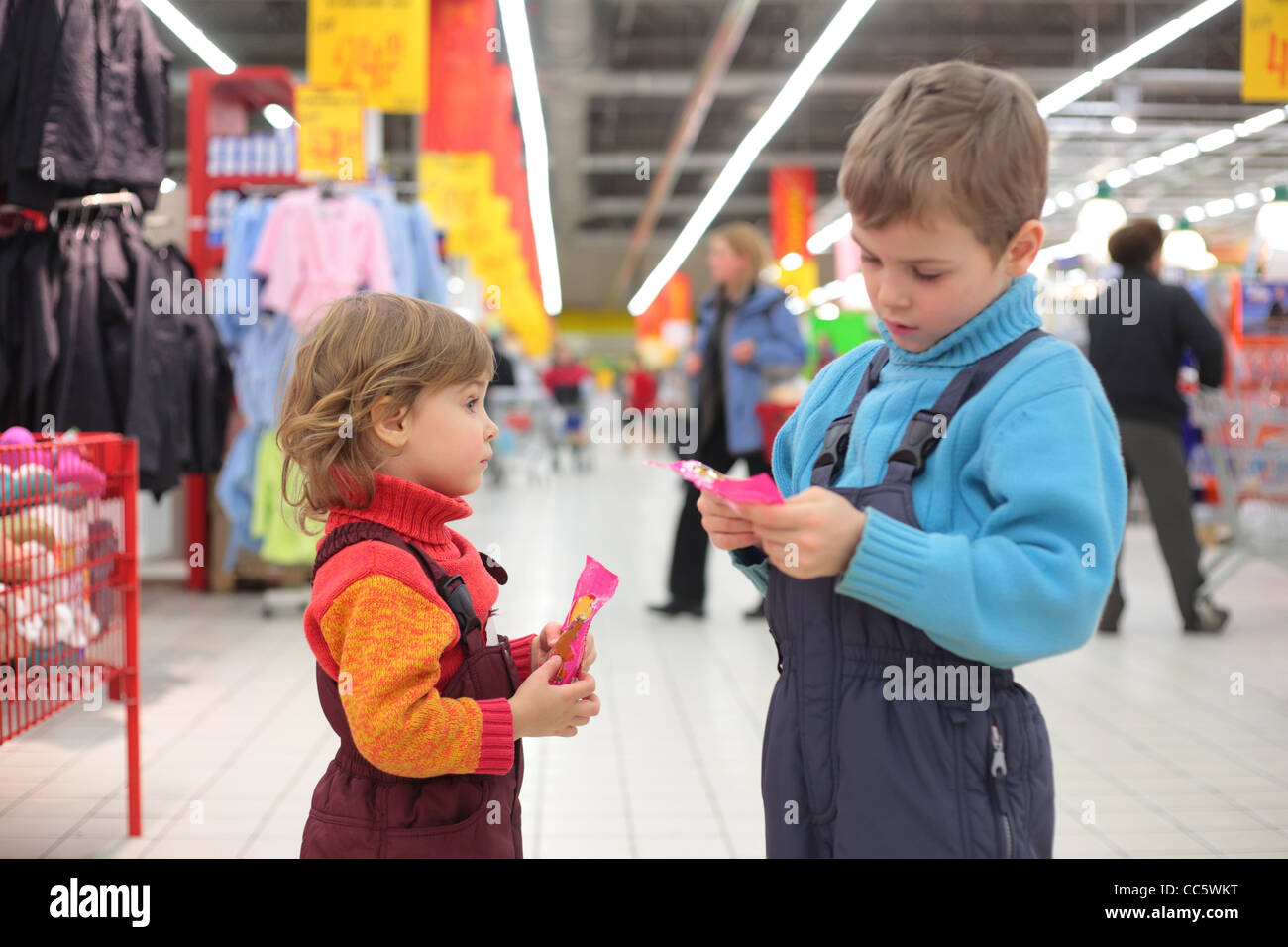 Kinder mit Süßigkeiten im Supermarkt, konzentrieren sich auf kleine Mädchen Stockfoto