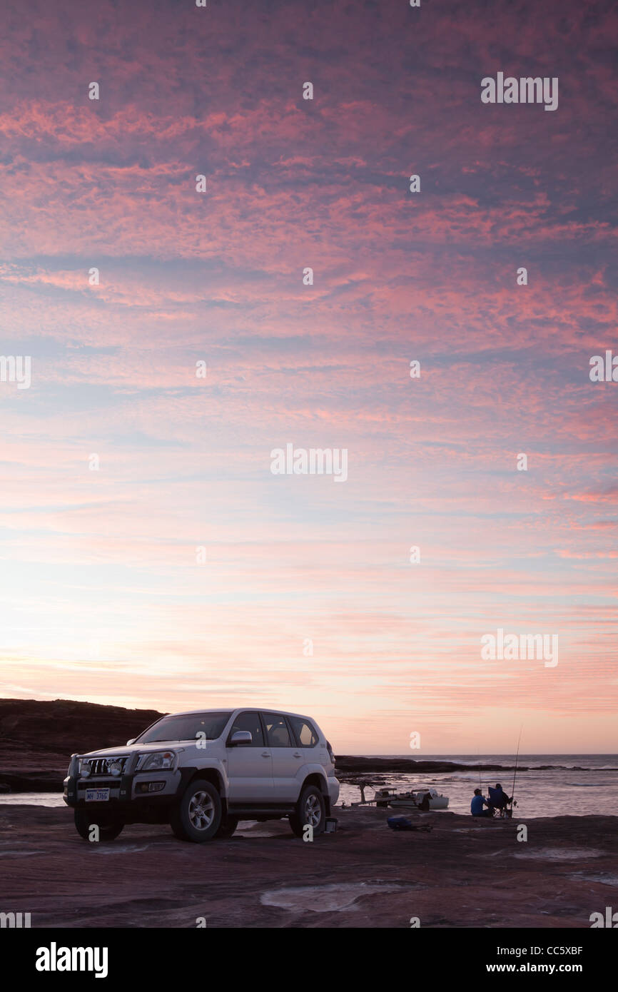 Toyota Landcruiser hochgezogen auf Red Bluff Beach gegen einen atemberaubenden Sonnenuntergang. Stockfoto