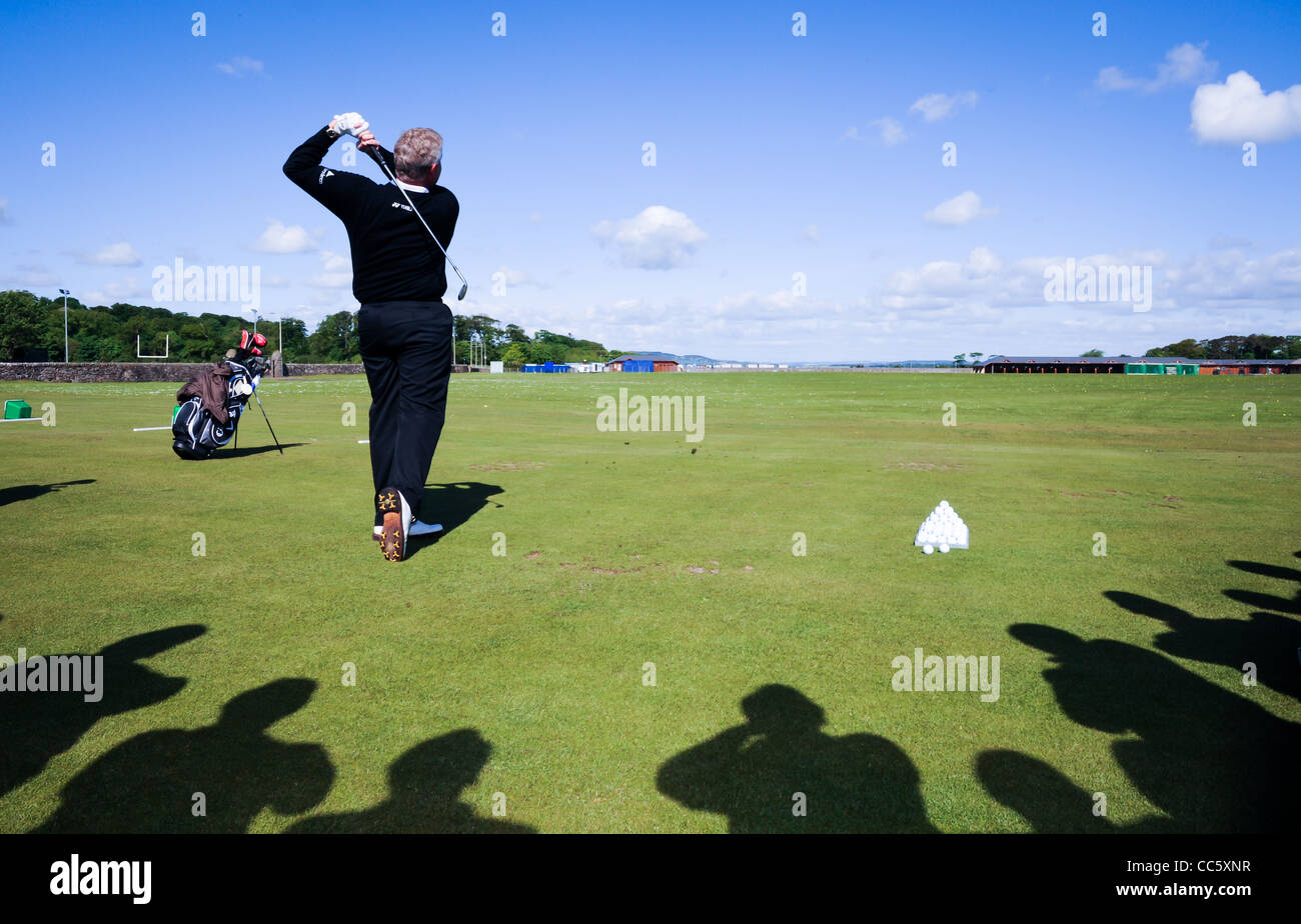 ein Profi-Golfer zeigt einen Golfschwung auf einem Golfplatz in Schottland an einem sonnigen blauen Himmel Tag Stockfoto
