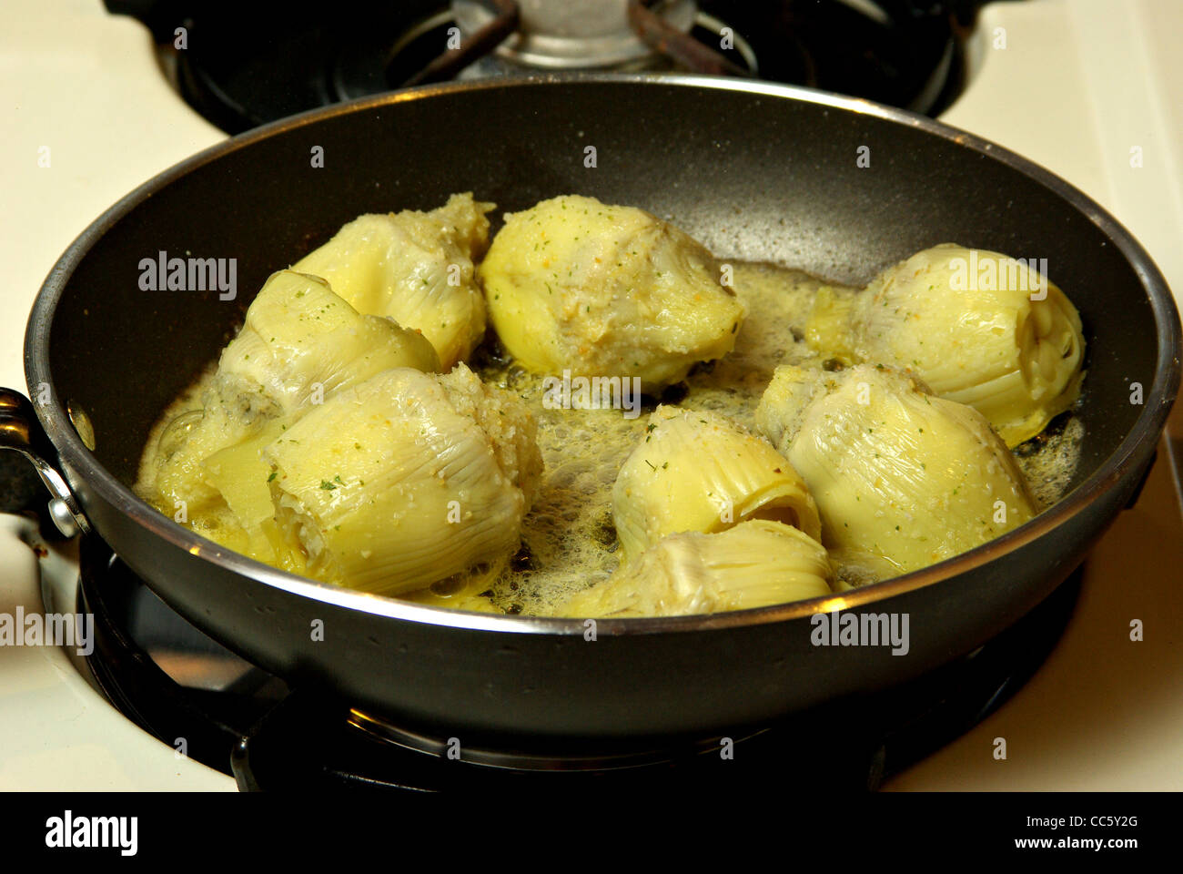 Artischockenherzen Kochen auf einem Herd. Stockfoto