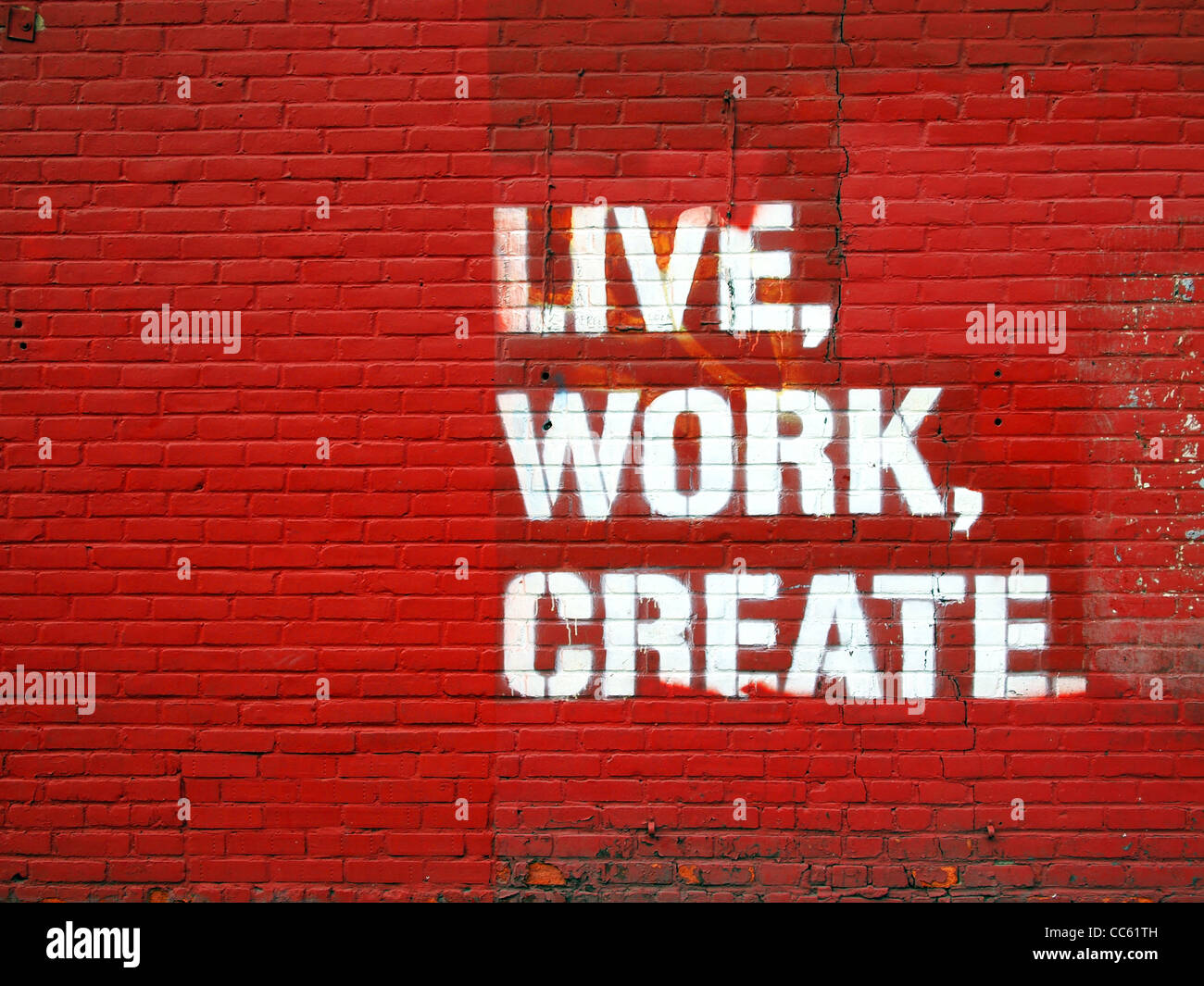 Die Worte Leben, arbeiten, lackiert auf roten Backsteinmauer in Manhattan, New York City zu schaffen. Stockfoto