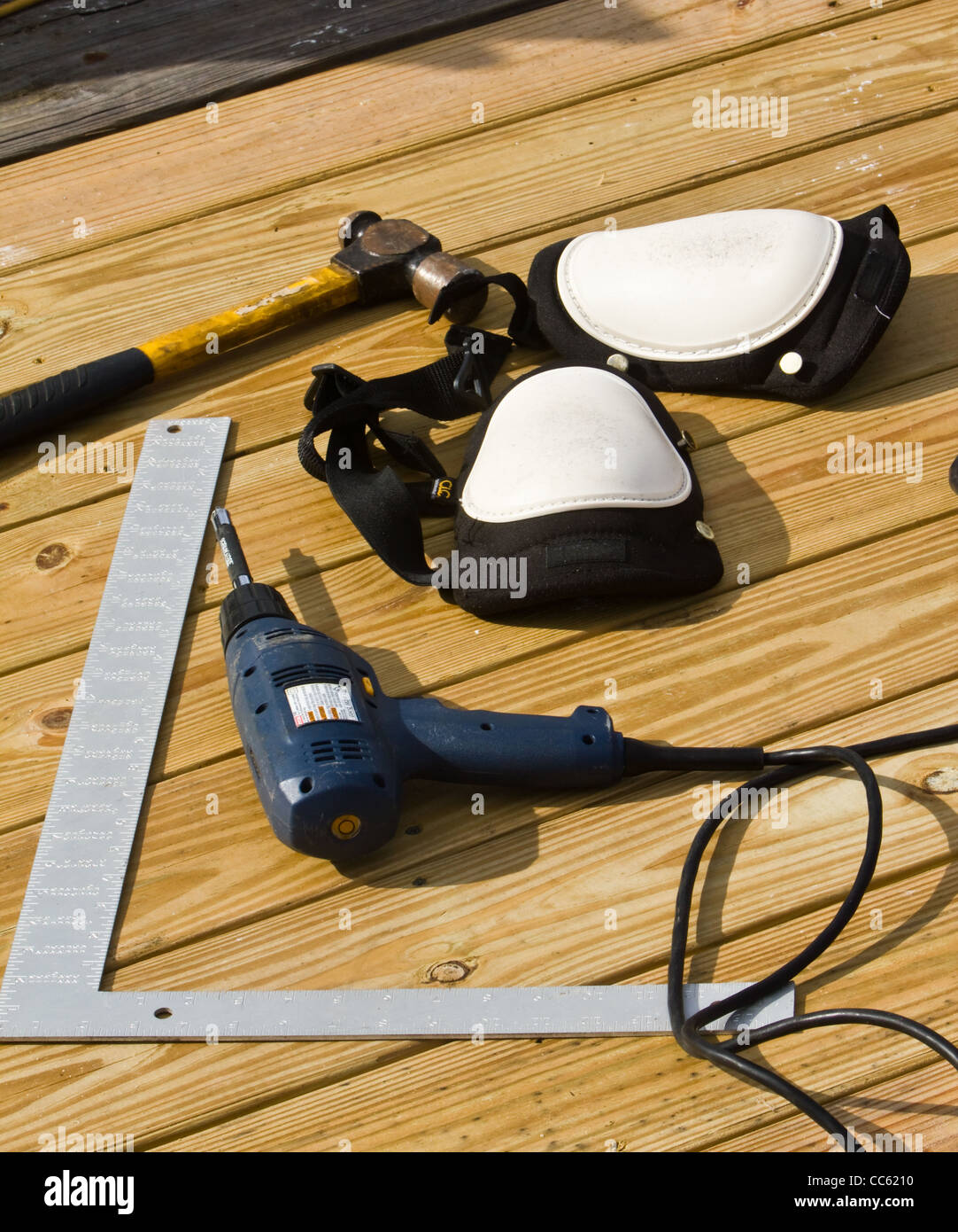 Der Tischler Werkzeug Verlegung in der Nähe, wo er arbeitet. Sein Hammer, Bohrer, Square und Knieschützer lag in der Nähe von seiner Arbeit. Stockfoto