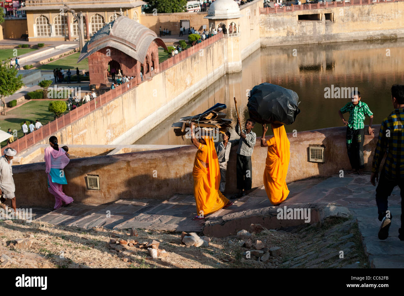 Frauen in Saris tragen schwerer Lasten auf ihren Köpfen, Amber Fort Palace, Jaipur, Rajasthan, Indien Stockfoto