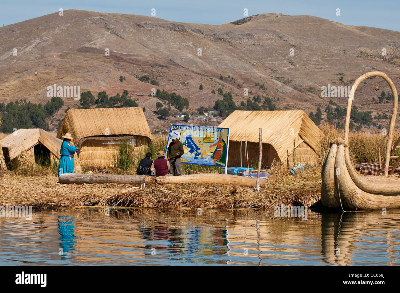 Peru, Titicaca-See. Quechua oder Uros Indianer Dorf auf die schwimmenden Inseln der Uros mit Reed-Boot. Stockfoto