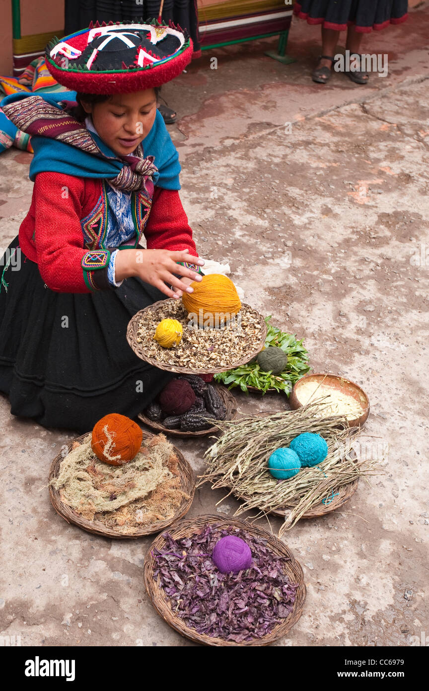 Peru, Chincheros. Peruanische Frau in traditioneller Kleidung mit gefärbten Kugeln aus Wolle in der lokalen Handwerker-Coop-Werkstatt. Stockfoto