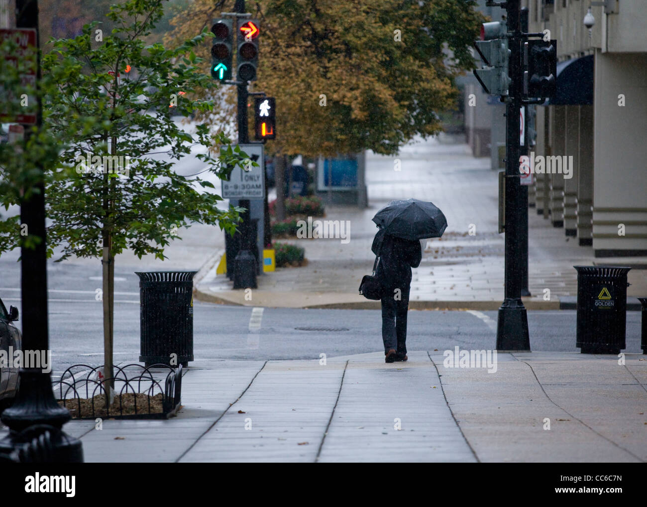 Ein Mann wartet auf die Straße zu überqueren, an einem regnerischen Tag Stockfoto