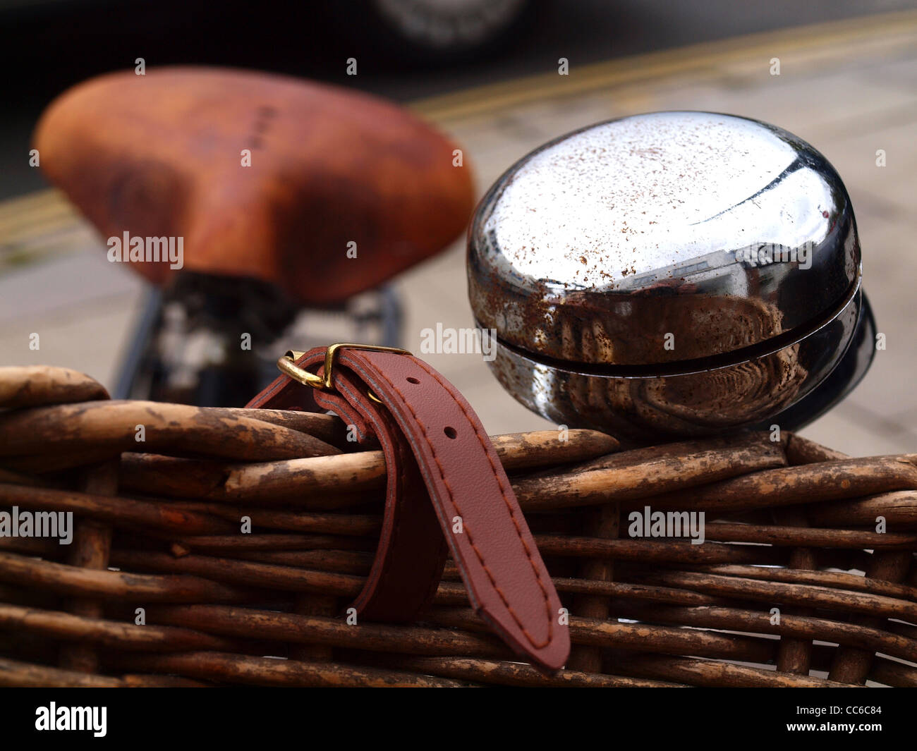 glänzende Glocke auf Vintage Fahrrad mit geflochtenen Korb und Leder Sattel Stockfoto