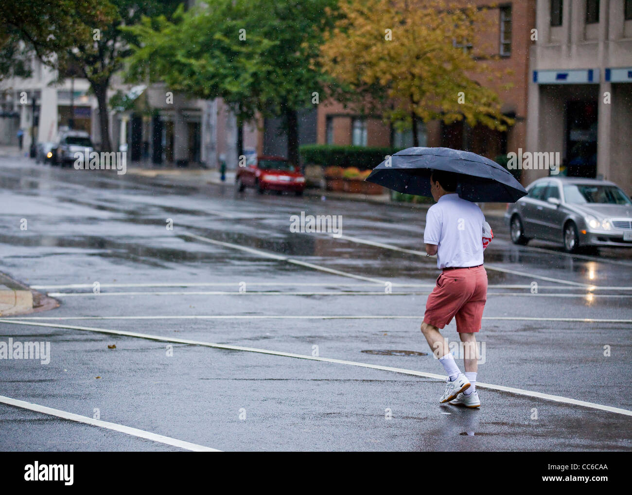 Ein Mann über die Straße an einem regnerischen Tag - USA Stockfoto