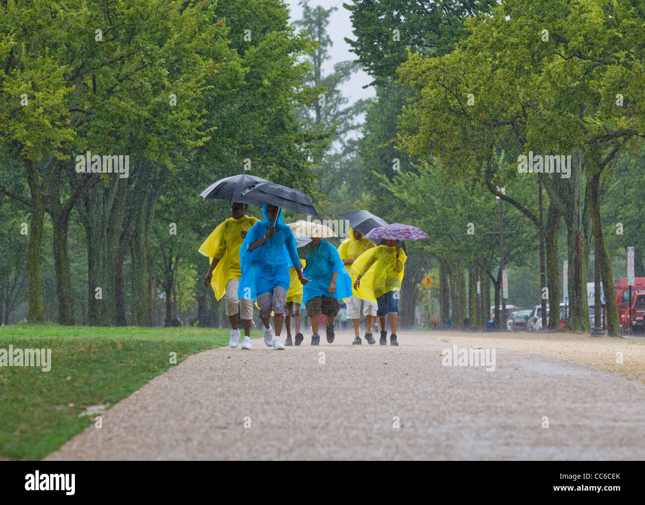 Eine afroamerikanische Familie, die bei starkem Regen läuft - USA Stockfoto