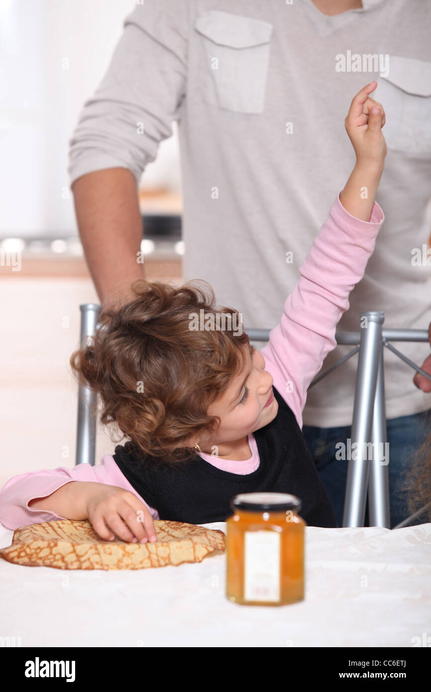 Glückliches Kind essen Pfannkuchen Stockfoto