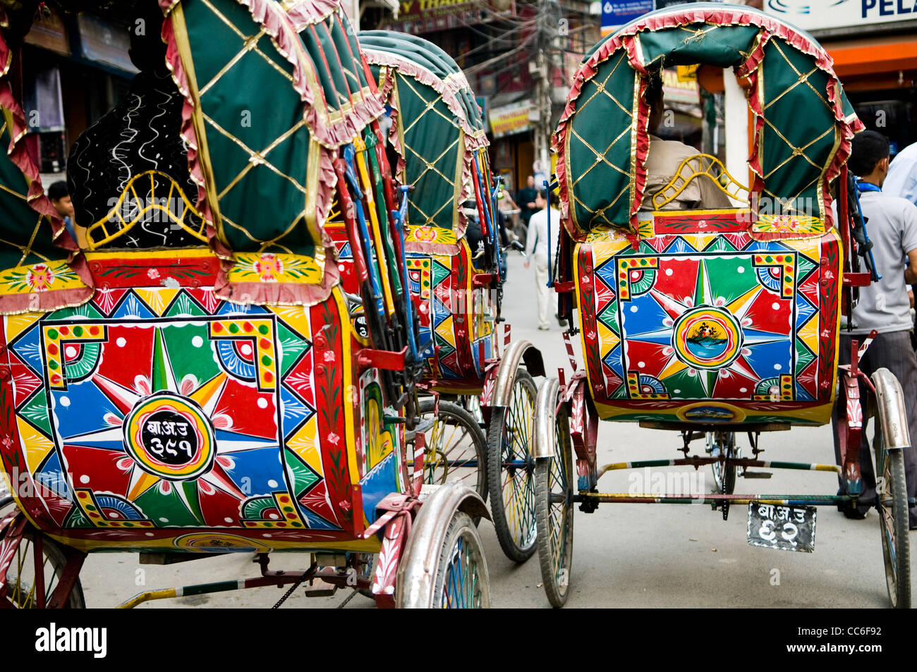 Bunte Fahrradrikschas, die durch die Straßen von Kathmandu. Stockfoto