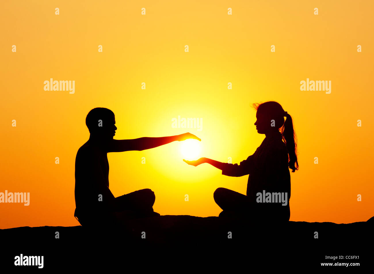 Indischer Mann und indische Mädchen halten die Sonne. Silhouette. Indien Stockfoto