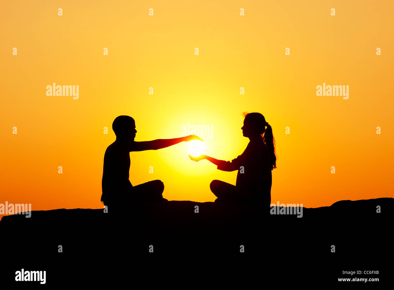 Indischer Mann und indische Mädchen halten die Sonne. Silhouette. Indien Stockfoto
